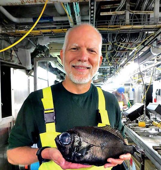 Jon Moore holding a spinyfin fish from Bear Seamount
